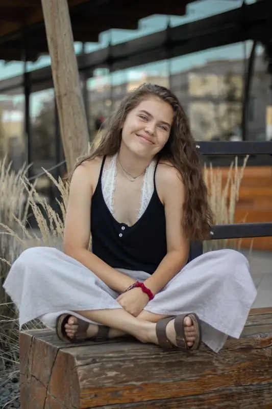 Young woman sitting on a wooden bench