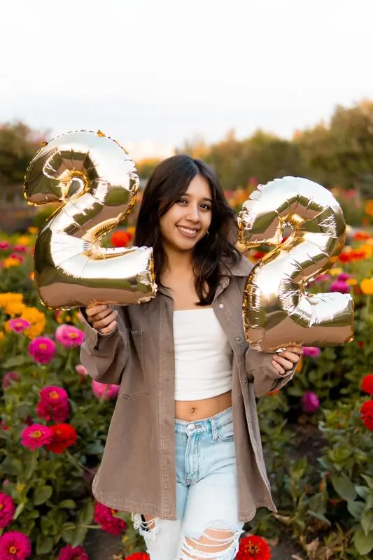 Person holding gold 22 balloons in a garden