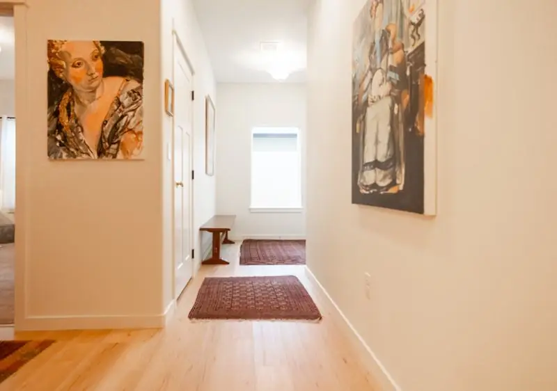 Hallway with paintings and rugs