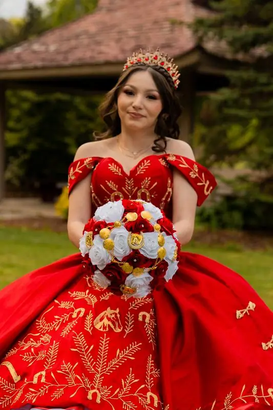 Young woman in an ornate red dress with roses and a crown