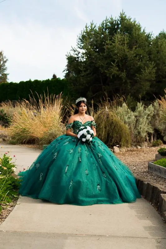 Young woman in a green ball gown holding a bouquet