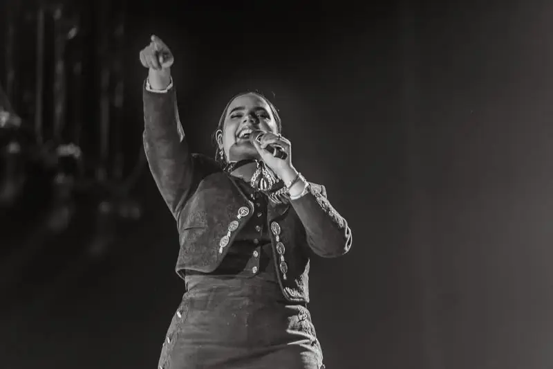 Black and white photo of a singer pointing upward