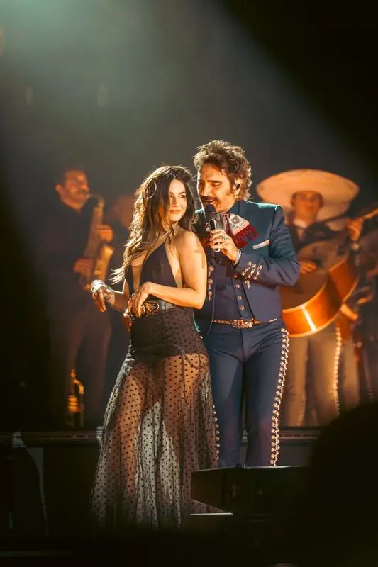 A man and woman singing with a mariachi band
