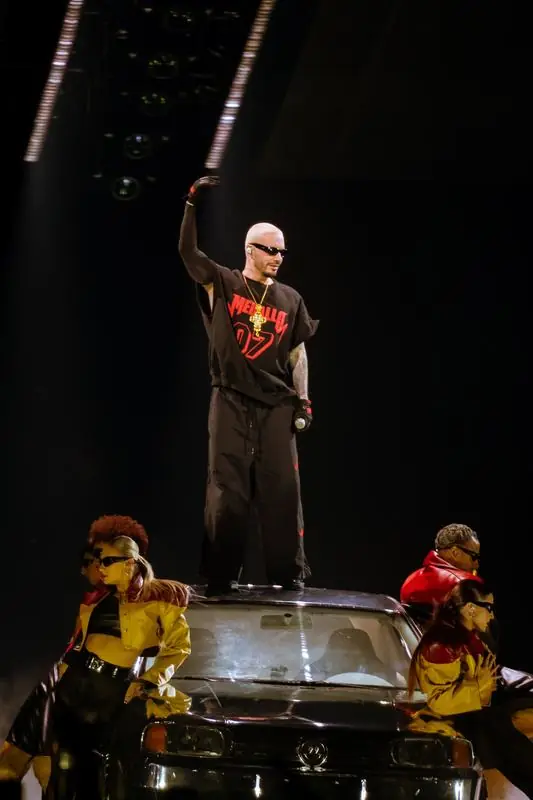 Performer standing on top of a black car