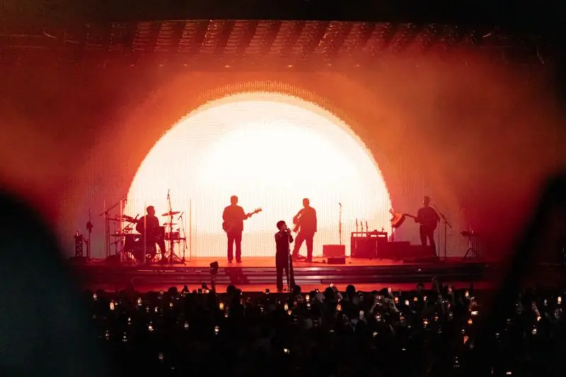 Band silhouetted against an orange circle