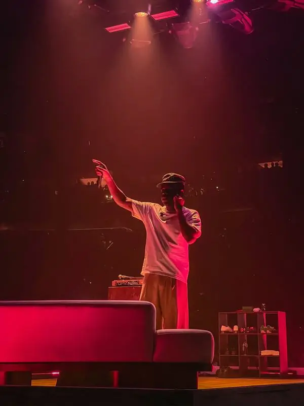 Performer in a hat under red light