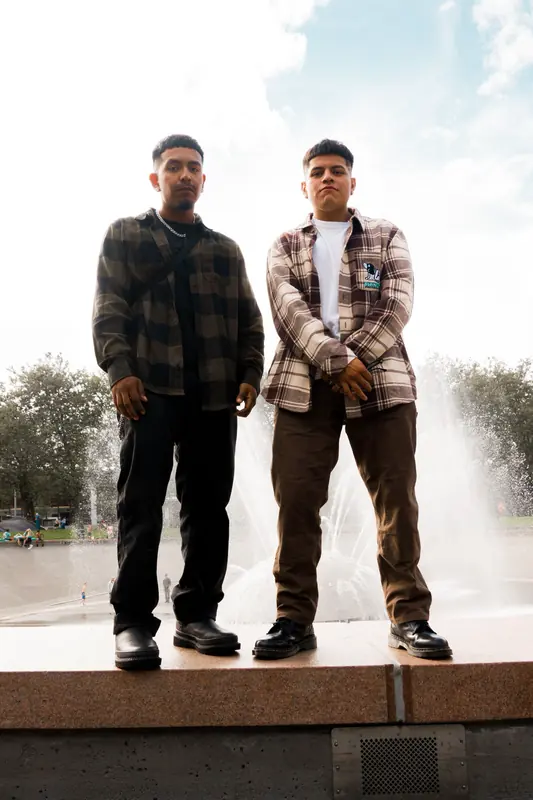 Two men in front of a fountain